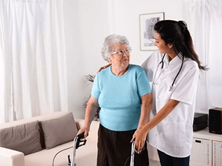 Pflegerin-hilft-Seniorin-mit-Rollstuhl