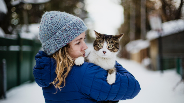 woman holding cat in the snow