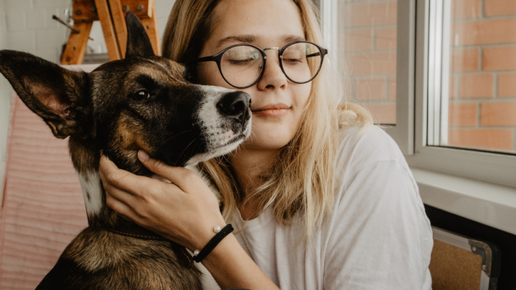 Young woman gives dog a hug