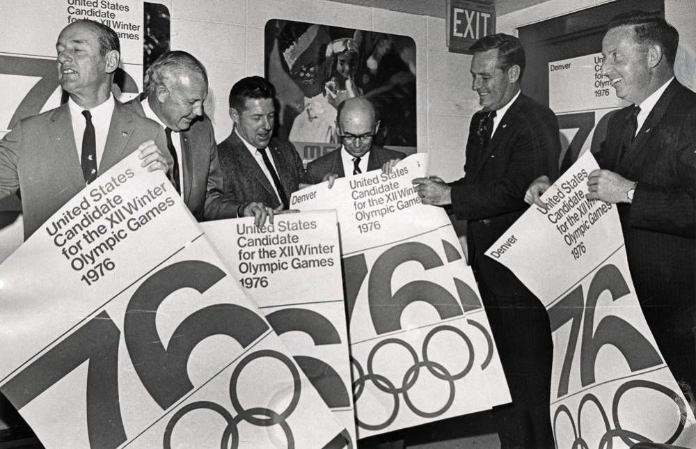 Members of the DOC showing off their bid posters at the airport as they prepare to fly to Mexico City for the 1968 Summer Olympic Games