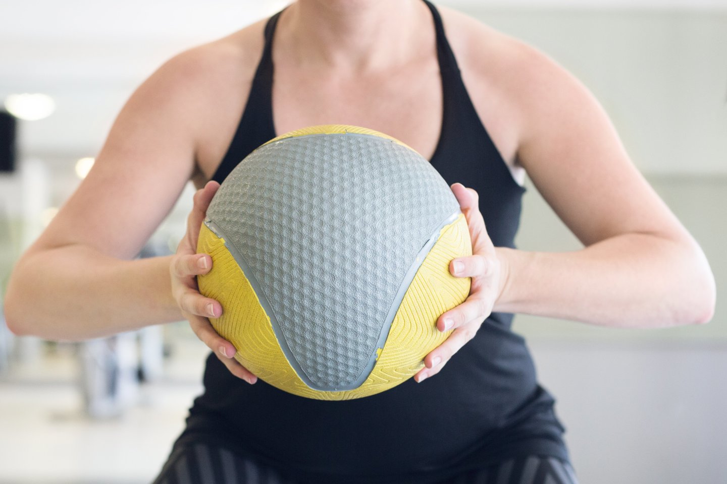 woman squeezing medicine ball