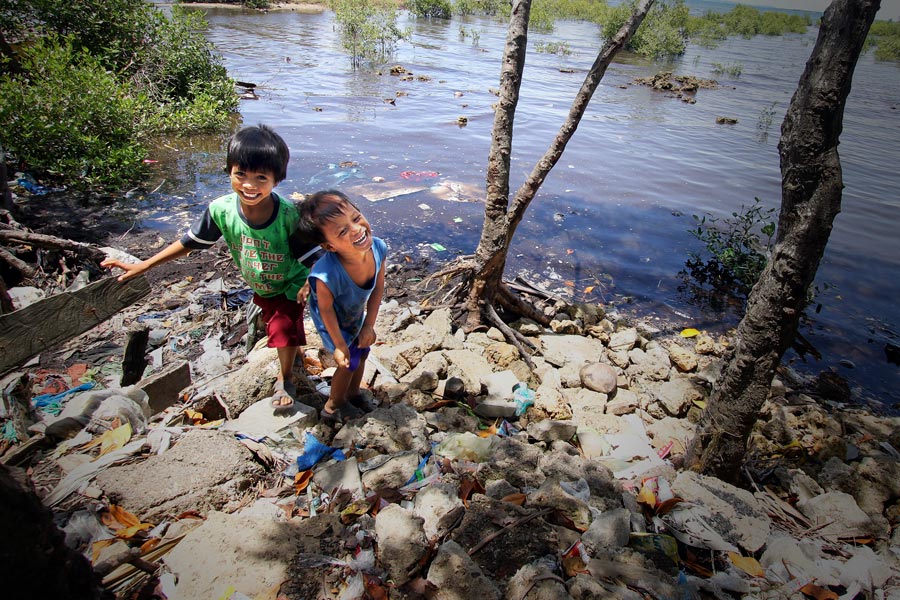 Two boys playing beside a river in the Philippines