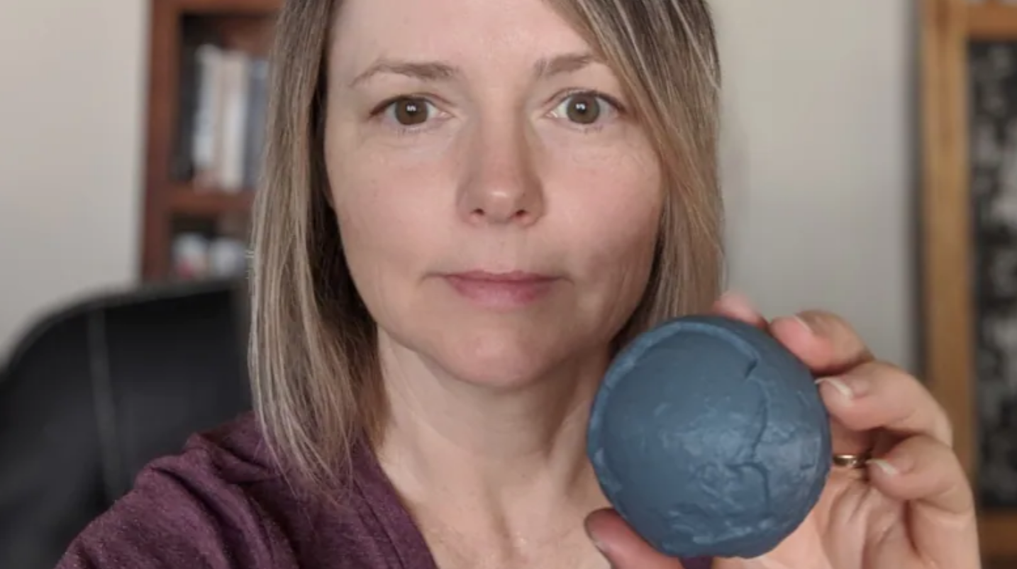 University of Calgary paleontologist Darla Zelenitsky holds a 3D printed model of the fossil turtle egg, which was about the size and shape of a tennis ball. (Darla Zelenitsky)
