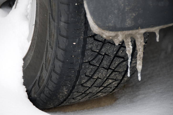 Icicles and a winter tire in a snowstorm