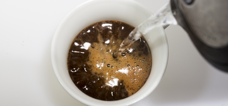 kaffebønner overhældes med vand fra elkedel