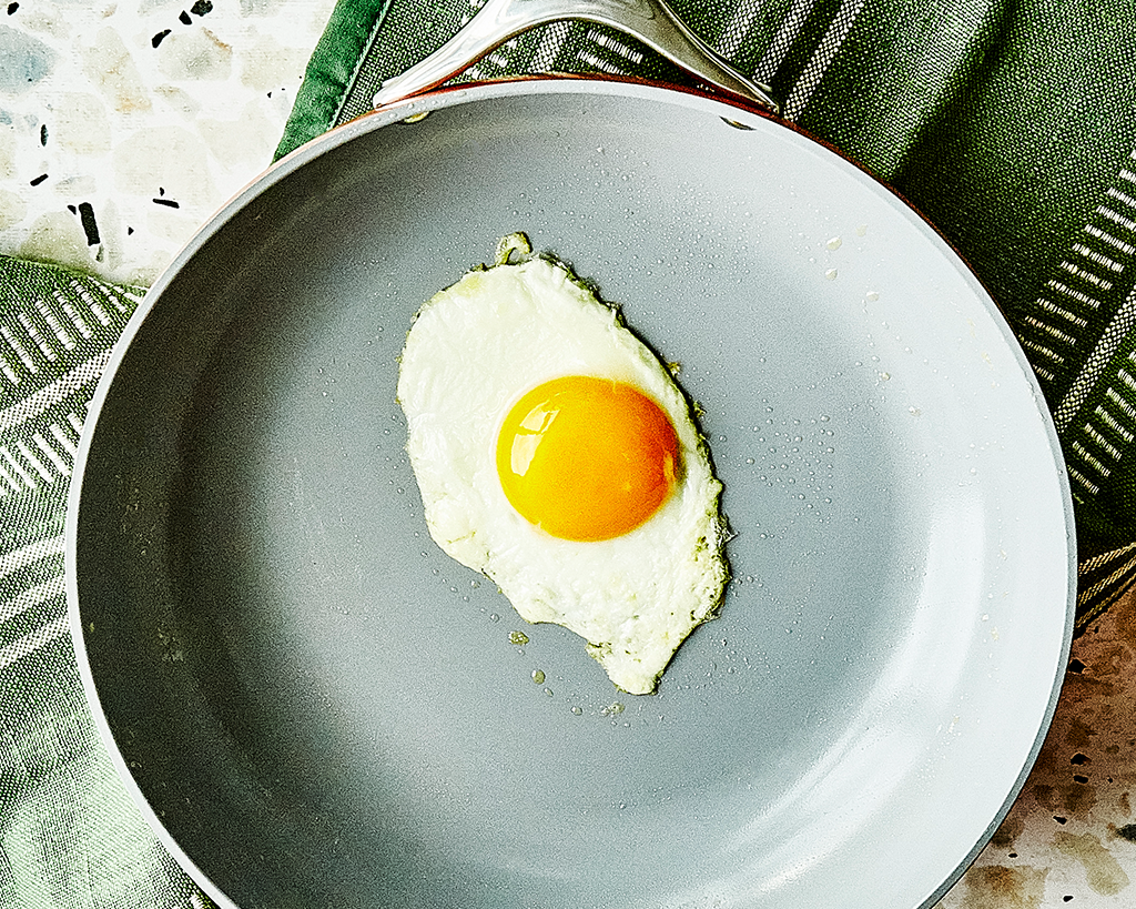 an egg in a fry pan ready to be flipped with a spatula
