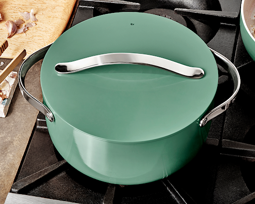 A sage green non-stick dutch oven on a stove top