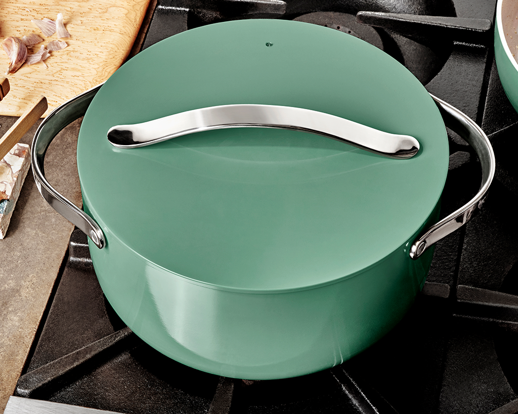 A sage green nonstick dutch oven resting on a stove top