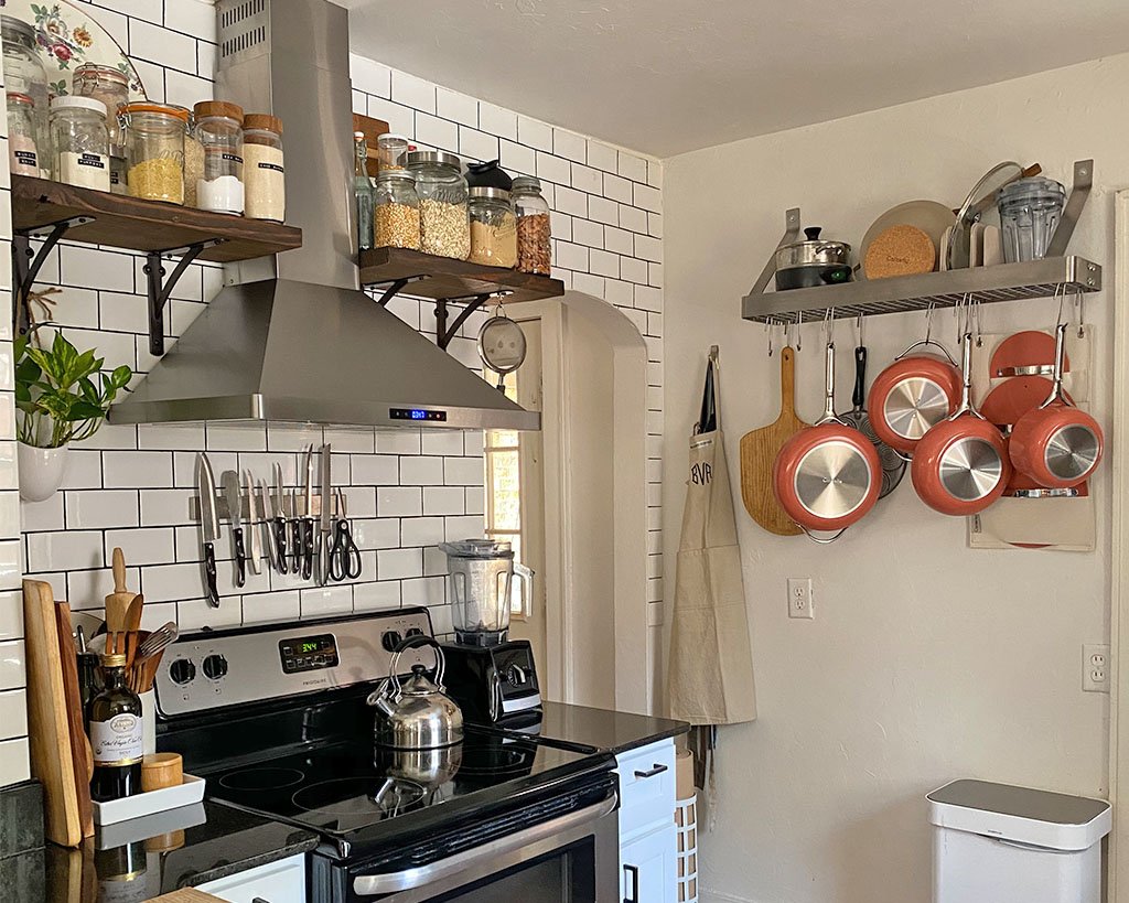 Pots, pans, and ceramic nonstick cookware being stored vertically for kitchen organization