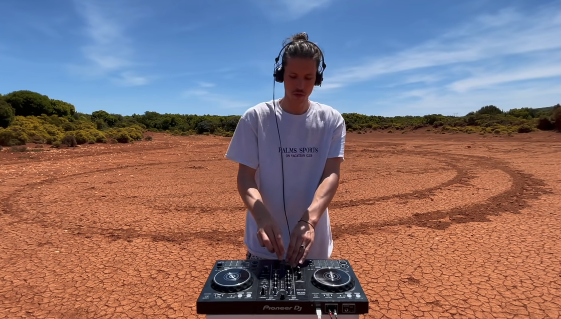 Chris Luno dj'ing in front of a background that looks like Mars