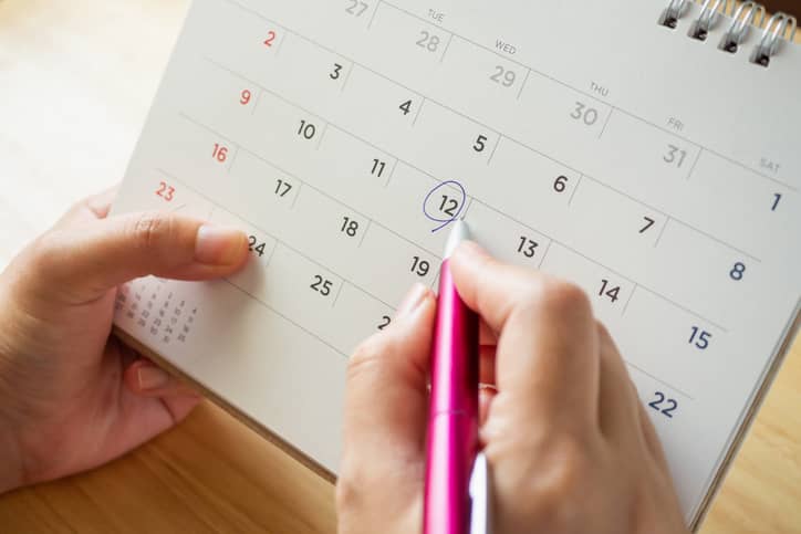 Woman working out when she'll ovulate and marking it on a calendar