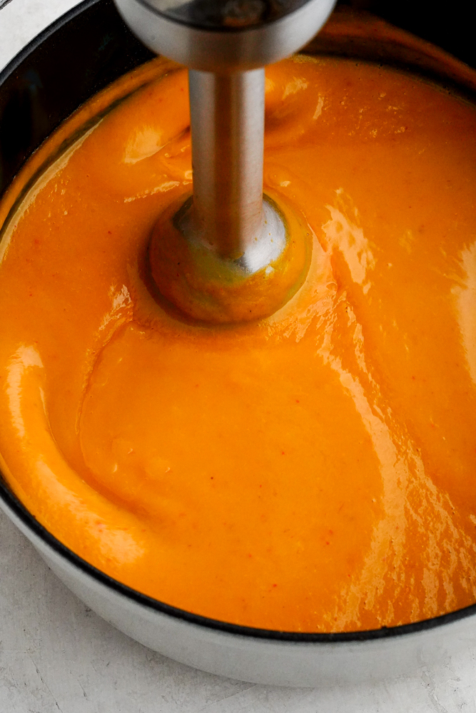 an immersion blender added to curried butternut squash soup