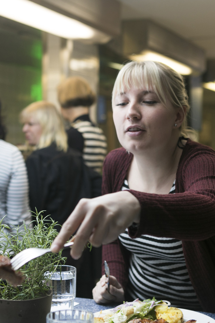 Haaga-Helian opiskelija ojentaa haarukalla lihapalaa maistettavaksi kampuksen pop-up-keittiössä.