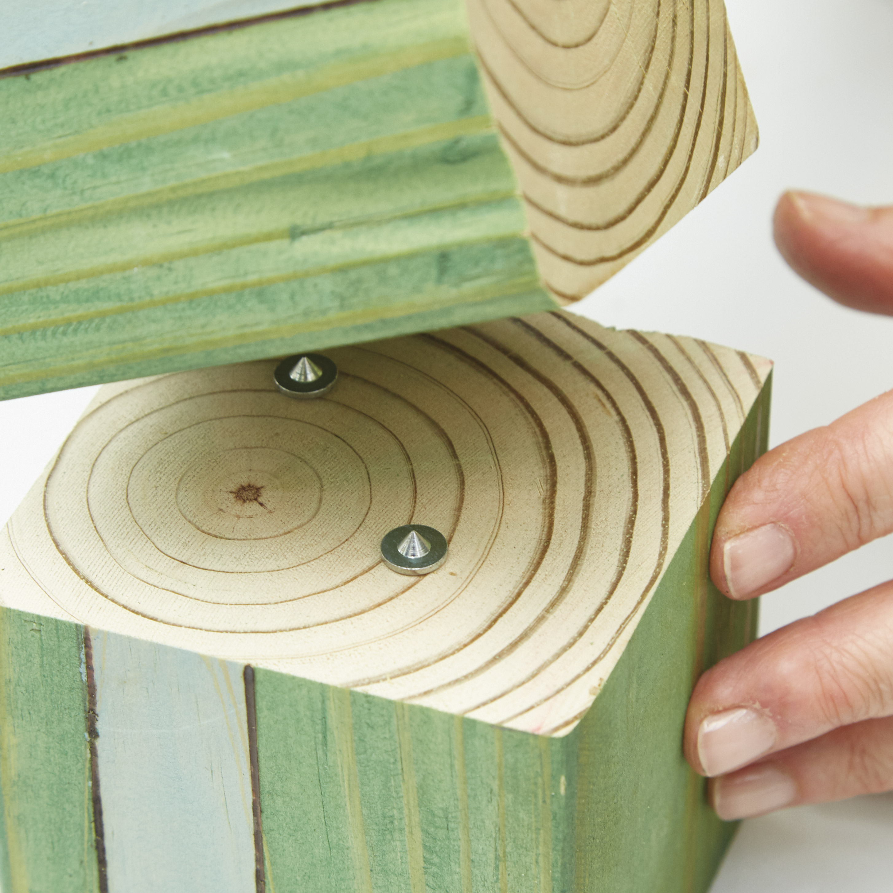 diy-garden-poles-dowel-pins: A dowel center fits in the drilled hole and has a sharp point to mark the block above. Line up and press the top block down onto the points.