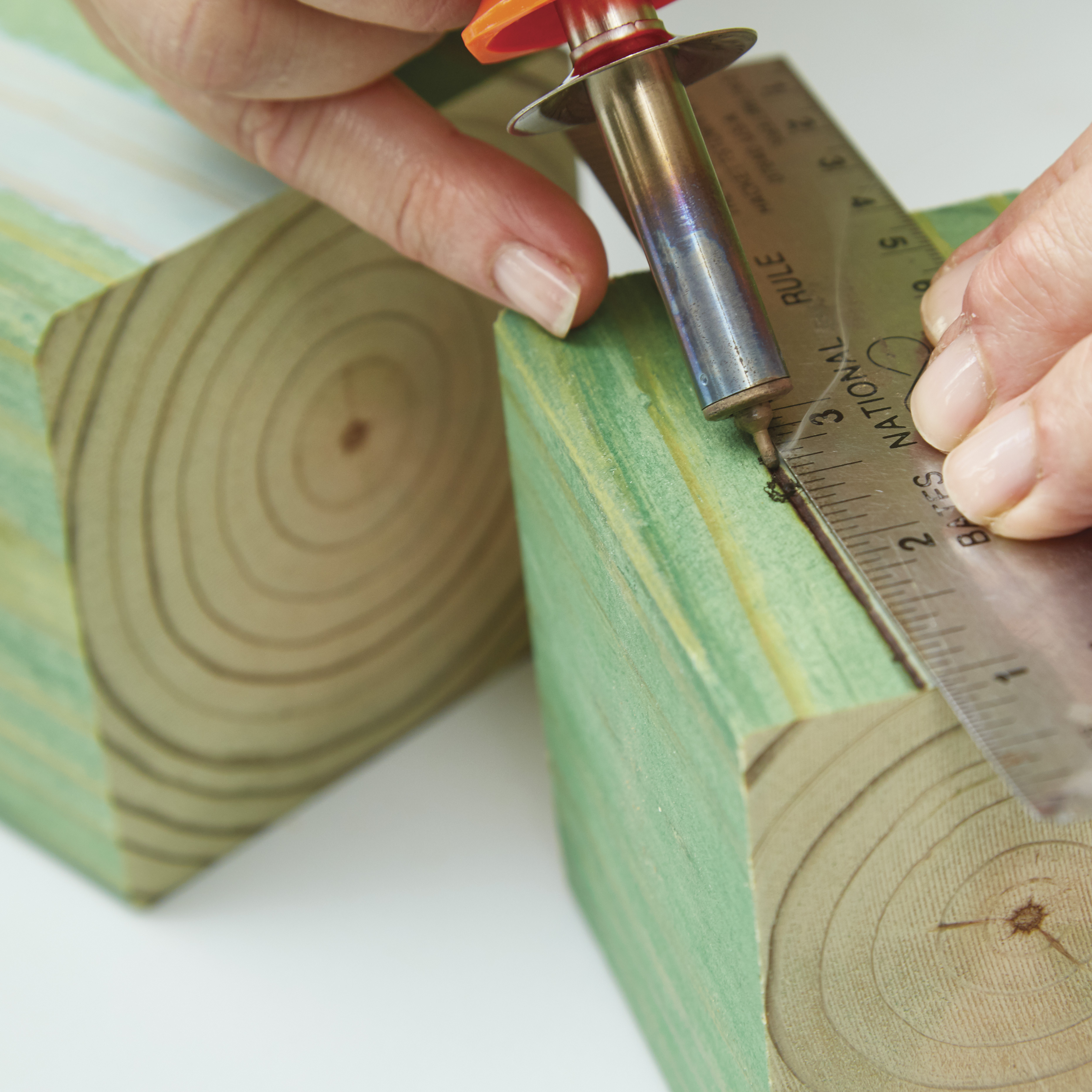 diy-garden-poles-woodburn: Resting your hand on a second block gives added control while using the wood-burning tool.