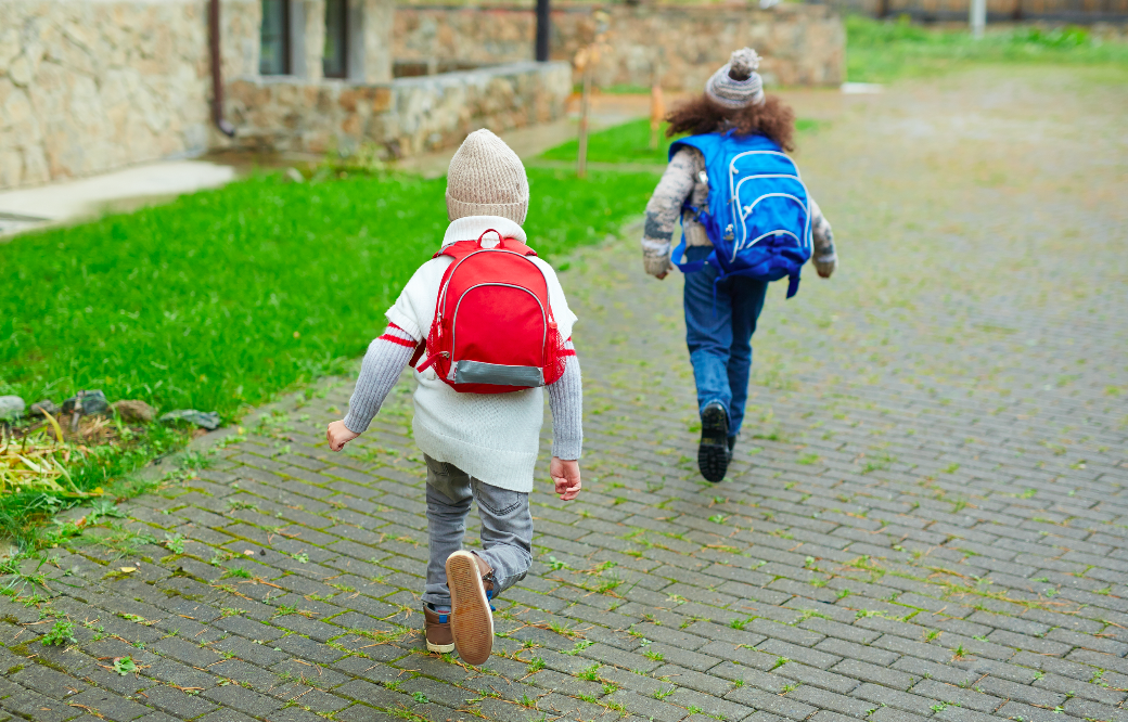 Children running to school with their back-to-school kits and back to school bags